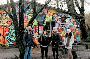 four students by a graffiti mural